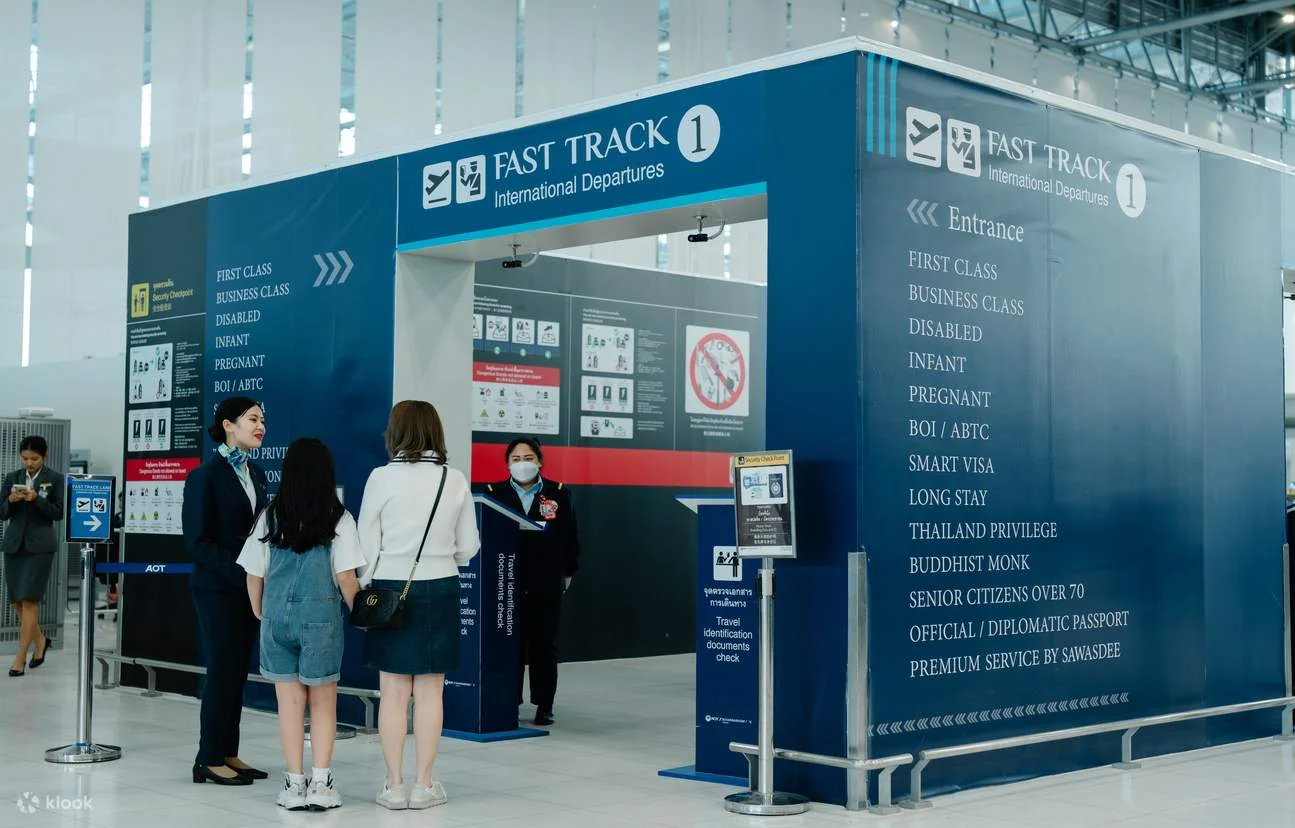 Airport premium service staff assisting passengers at the Fast Track entrance